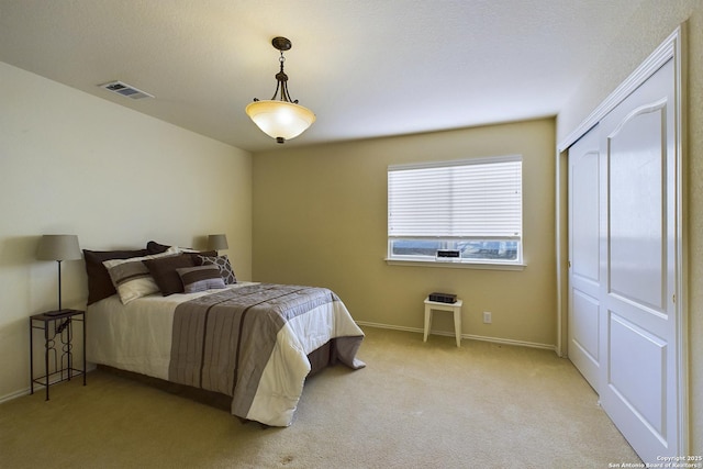 bedroom featuring light colored carpet and a closet