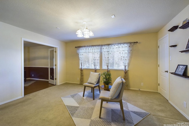 living area featuring carpet floors, a textured ceiling, and an inviting chandelier