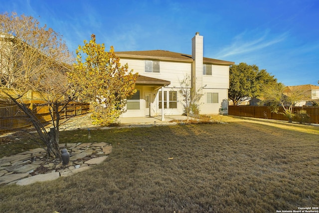 rear view of house with a patio area and a lawn