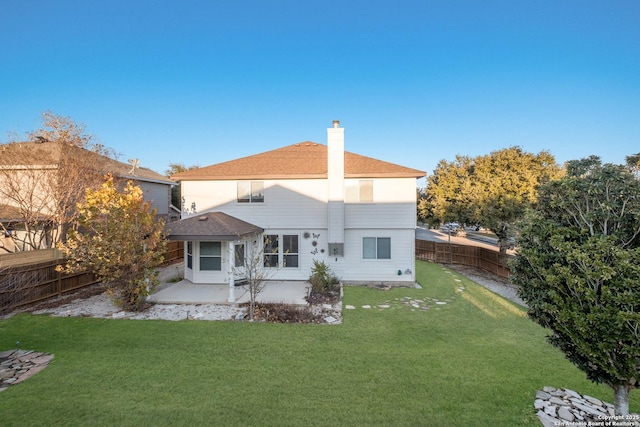 back of house with a patio area and a lawn