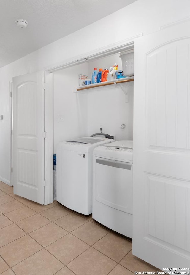 laundry area with light tile patterned floors and washer and clothes dryer