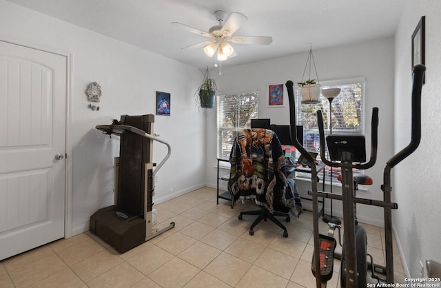 workout area featuring ceiling fan, a wealth of natural light, and light tile patterned floors