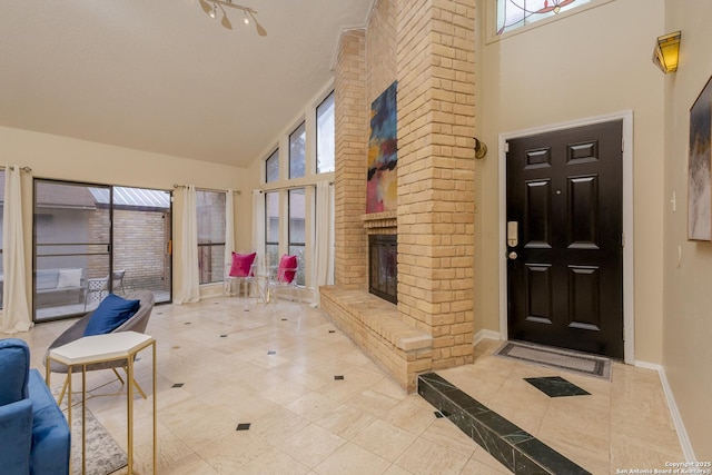 interior space featuring a fireplace, a healthy amount of sunlight, and high vaulted ceiling