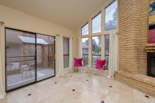 entryway with a fireplace, light tile patterned floors, and high vaulted ceiling