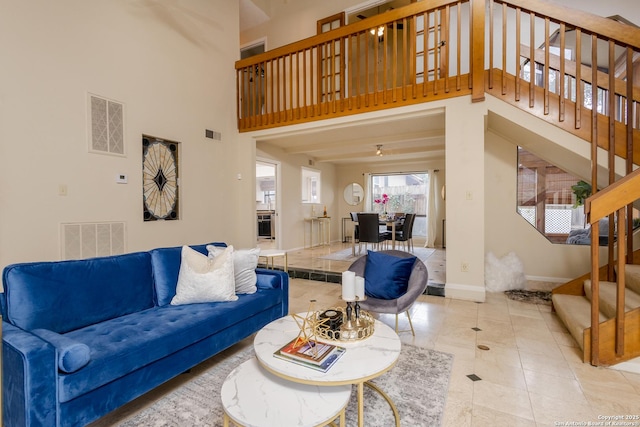 living room featuring a towering ceiling and light tile patterned flooring