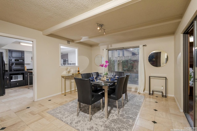 dining area featuring beam ceiling, light tile patterned floors, and a textured ceiling