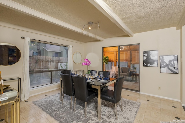 dining area with a wealth of natural light, a textured ceiling, beam ceiling, and light tile patterned flooring