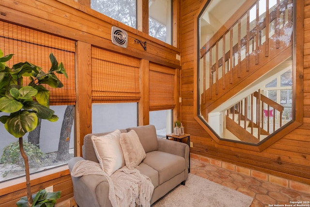 tiled living room featuring wood walls