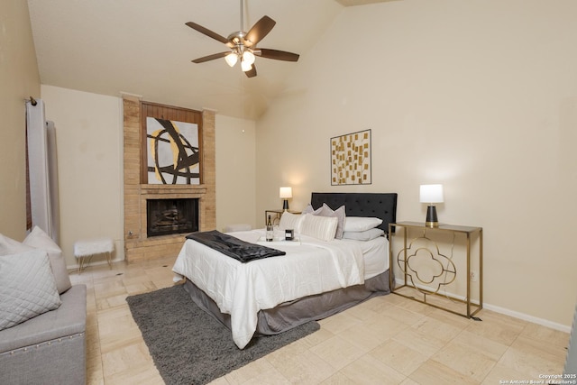 bedroom with ceiling fan, high vaulted ceiling, and a brick fireplace