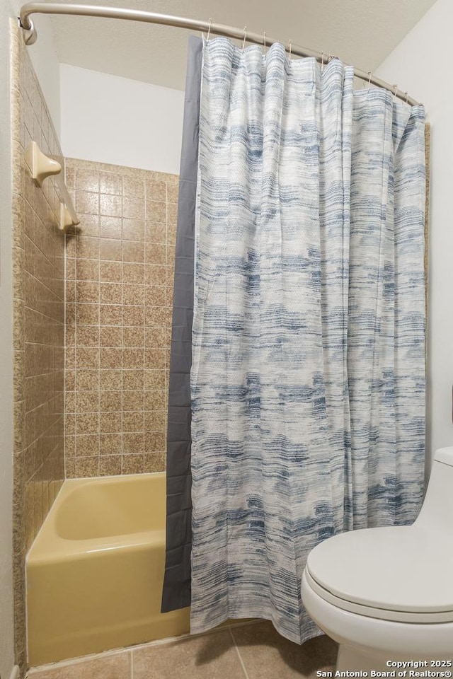 bathroom featuring toilet, shower / bath combination with curtain, and tile patterned flooring