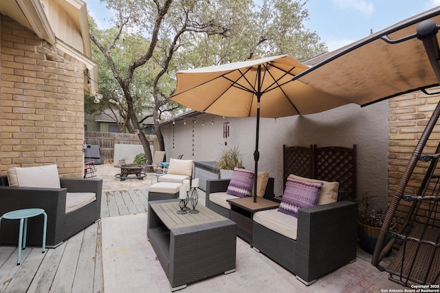 view of patio / terrace featuring a wooden deck and an outdoor living space with a fire pit