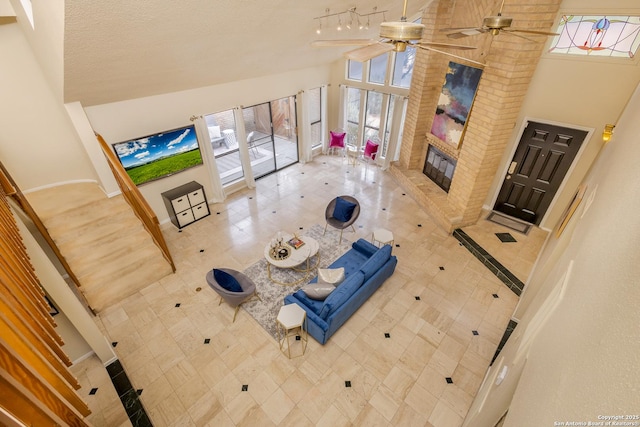 living room featuring ceiling fan, high vaulted ceiling, a brick fireplace, and tile patterned floors