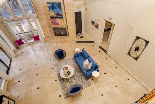 interior space with a brick fireplace, a high ceiling, and tile patterned floors