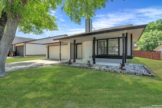 single story home with a front yard, a carport, and a garage