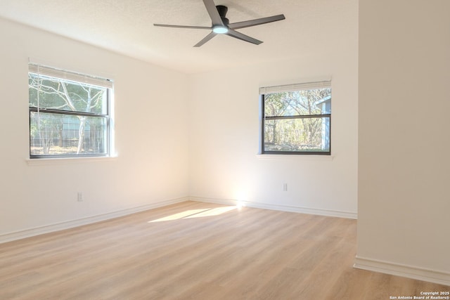 empty room with ceiling fan and light hardwood / wood-style floors