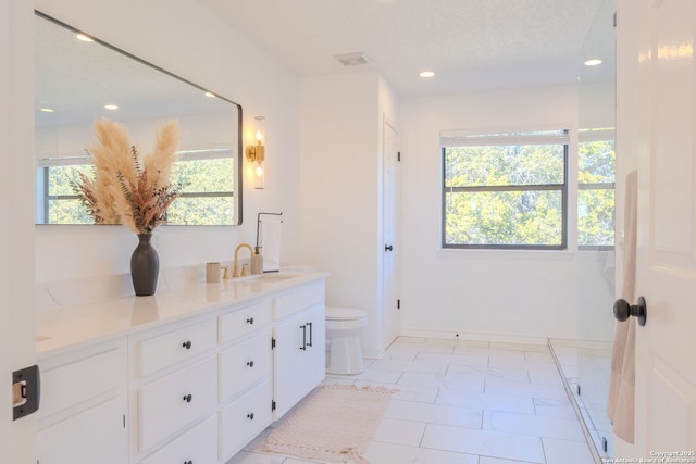 bathroom featuring a textured ceiling, toilet, and vanity