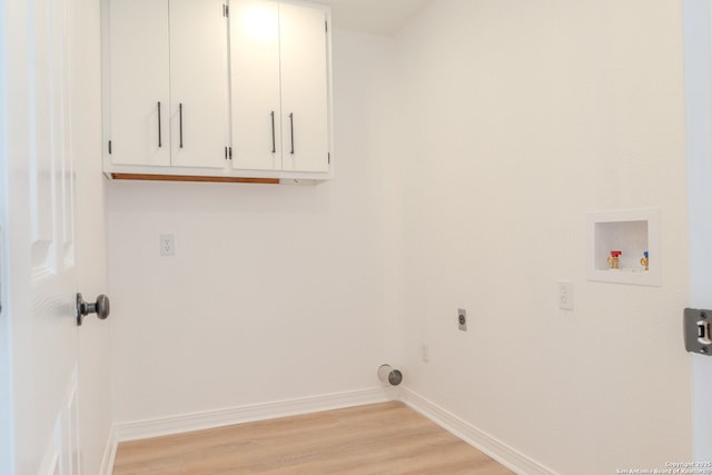 washroom featuring washer hookup, electric dryer hookup, light hardwood / wood-style floors, and cabinets