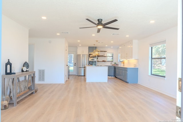 living room with light hardwood / wood-style floors, a textured ceiling, and ceiling fan