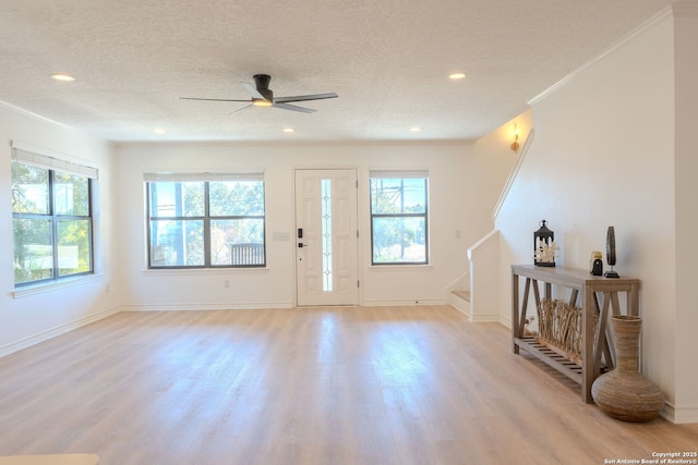 entryway featuring ceiling fan, a textured ceiling, crown molding, and light wood-type flooring