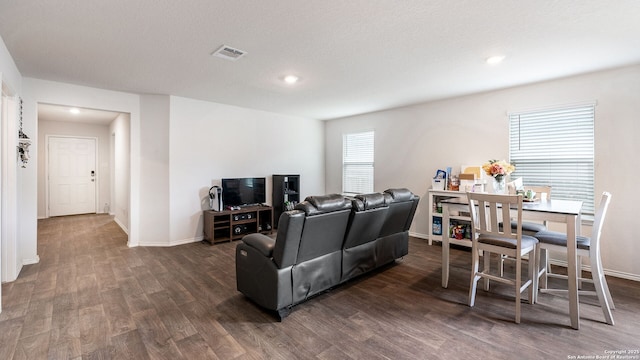 living room featuring dark wood-type flooring and a textured ceiling