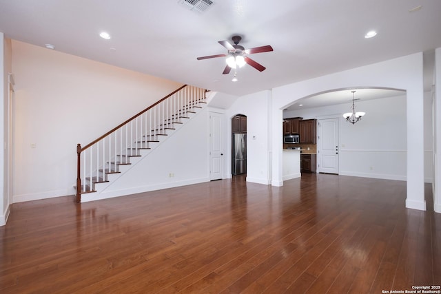 unfurnished living room featuring dark hardwood / wood-style floors and ceiling fan with notable chandelier