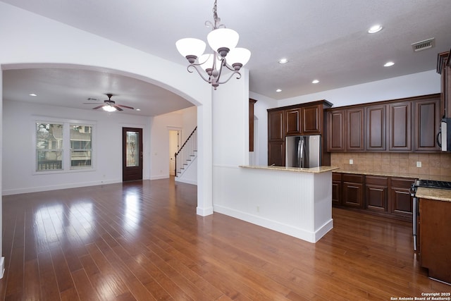 kitchen featuring dark brown cabinetry, decorative light fixtures, tasteful backsplash, and stainless steel appliances