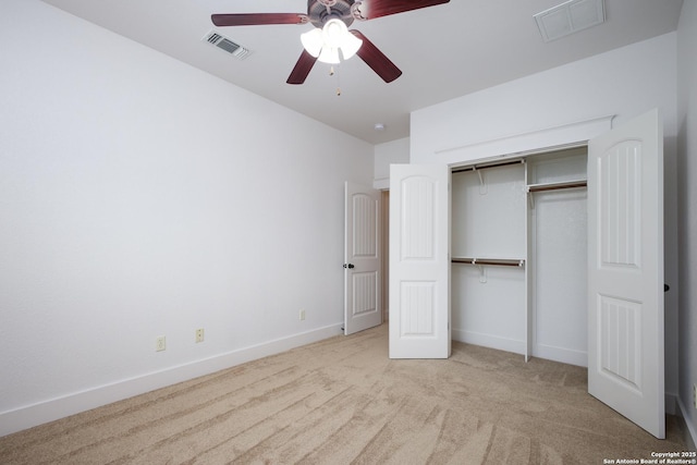 unfurnished bedroom with light colored carpet, a closet, and ceiling fan