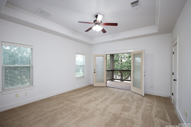 unfurnished room with light carpet, crown molding, a raised ceiling, and ceiling fan