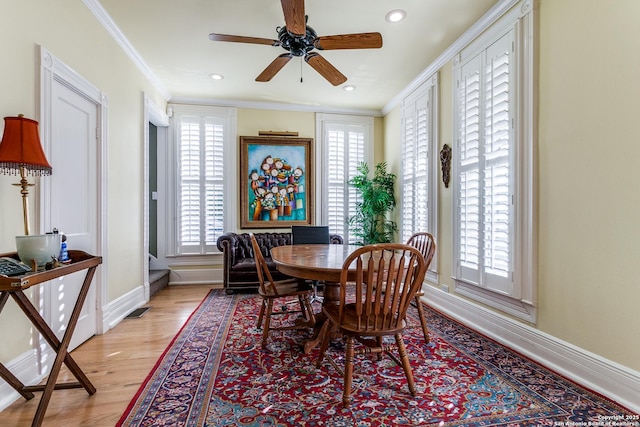 dining space with crown molding, light wood-type flooring, and ceiling fan