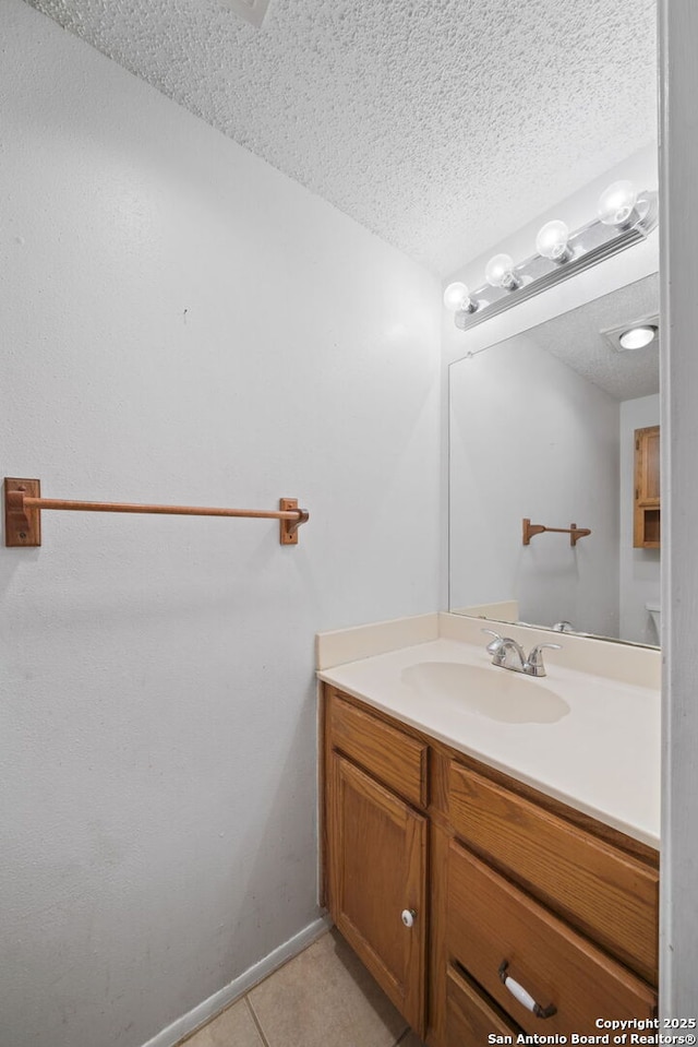 bathroom featuring vanity, a textured ceiling, and tile patterned flooring