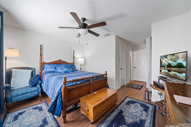 bedroom with ceiling fan, hardwood / wood-style floors, and a textured ceiling