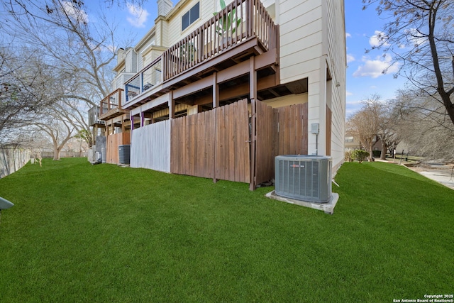 view of side of home featuring central AC unit and a yard