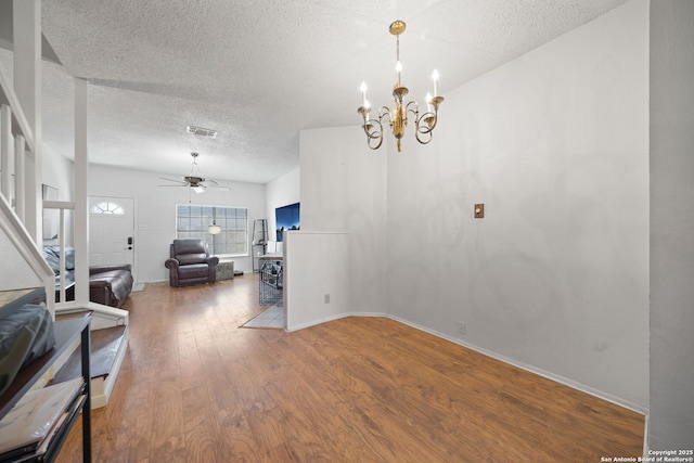 dining area featuring ceiling fan with notable chandelier, hardwood / wood-style floors, and a textured ceiling