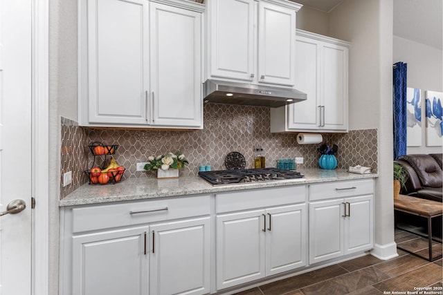 kitchen featuring stainless steel gas stovetop, white cabinetry, light stone countertops, and tasteful backsplash