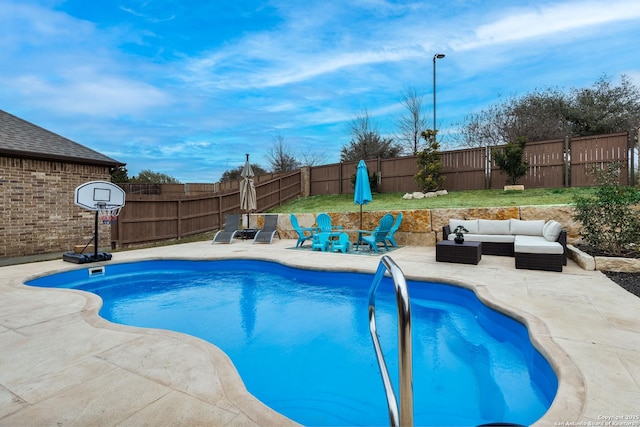 view of swimming pool featuring a patio area and an outdoor living space with a fire pit