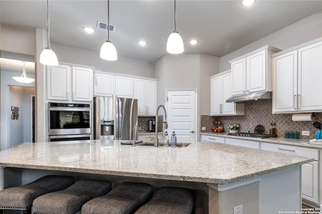 kitchen with white cabinetry, appliances with stainless steel finishes, hanging light fixtures, and a large island