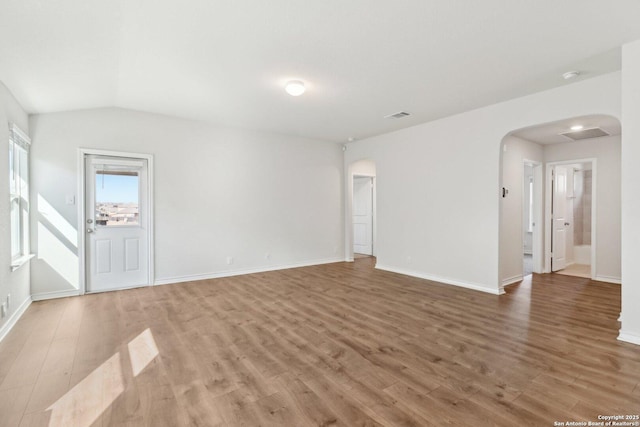 empty room with wood-type flooring and lofted ceiling