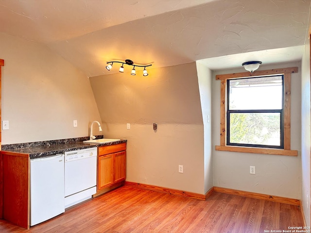 kitchen featuring lofted ceiling, white dishwasher, light hardwood / wood-style floors, and sink