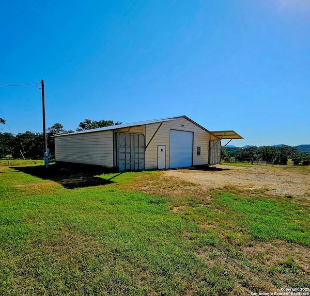 view of outbuilding with a garage and a yard