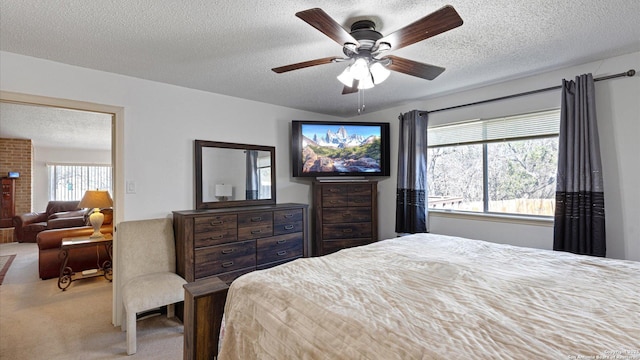 bedroom with light carpet, a textured ceiling, and a ceiling fan