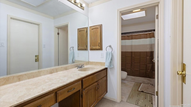 bathroom featuring toilet, vanity, and crown molding