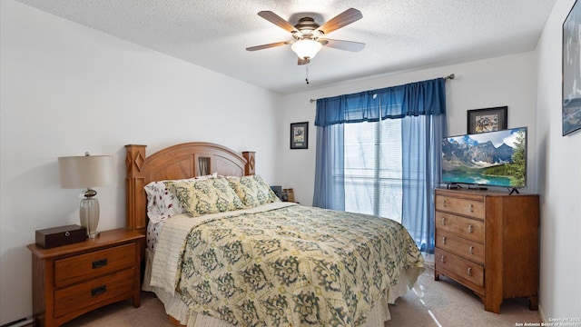 bedroom featuring light carpet, a ceiling fan, and a textured ceiling