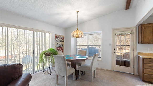 dining area featuring vaulted ceiling with beams, a textured ceiling, and light colored carpet