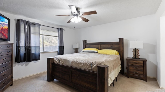 bedroom featuring light carpet, a textured ceiling, and a ceiling fan