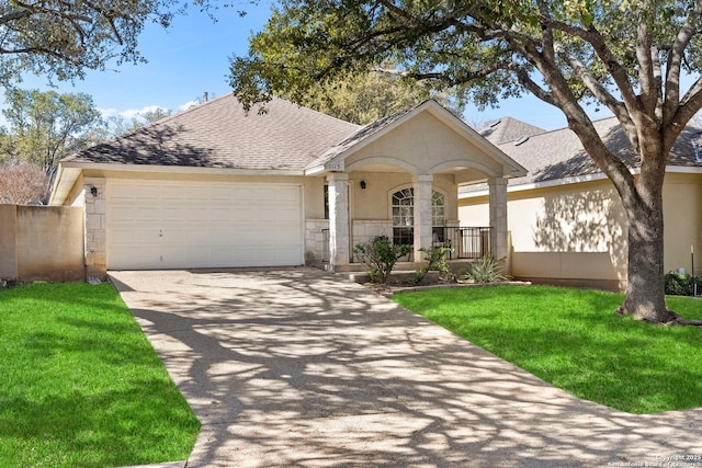 ranch-style house featuring covered porch, a front yard, and a garage