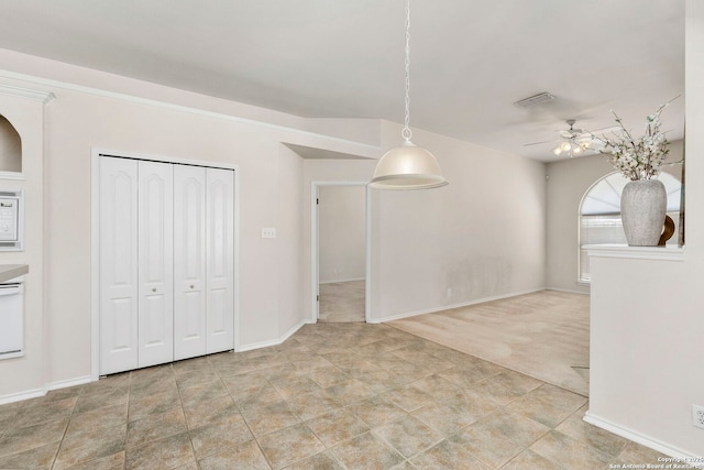 unfurnished dining area with ceiling fan and light carpet