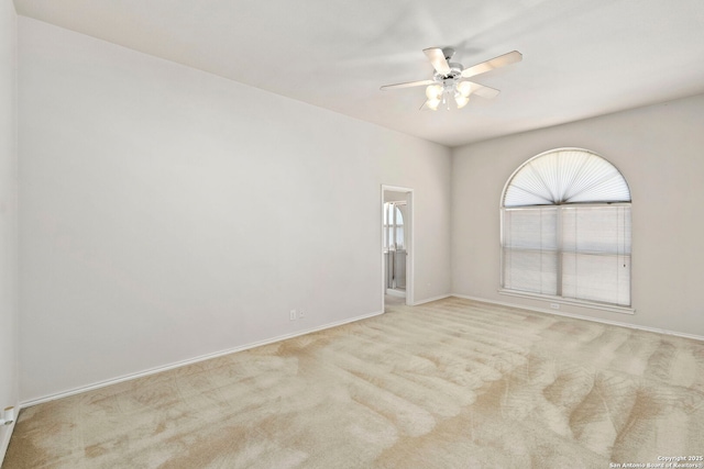 carpeted spare room featuring ceiling fan