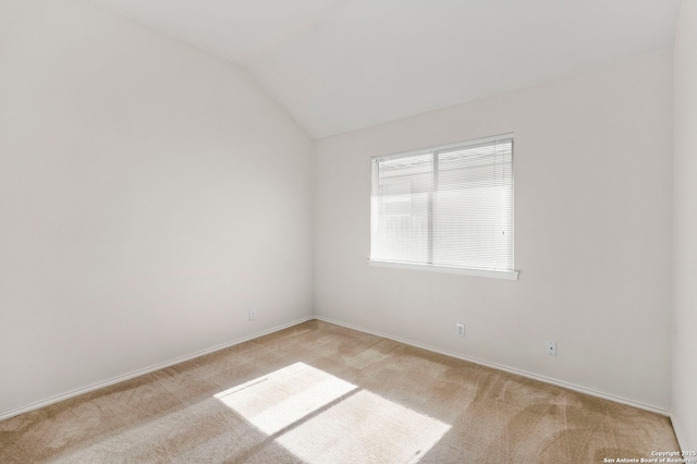 unfurnished room featuring light colored carpet and vaulted ceiling