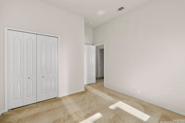 unfurnished bedroom with a closet and light carpet