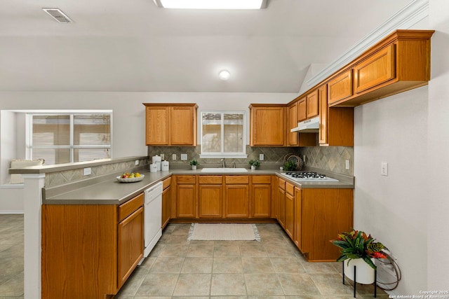 kitchen with kitchen peninsula, sink, tasteful backsplash, white appliances, and lofted ceiling